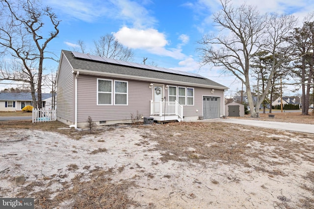 view of front of home with a garage, central AC, and solar panels