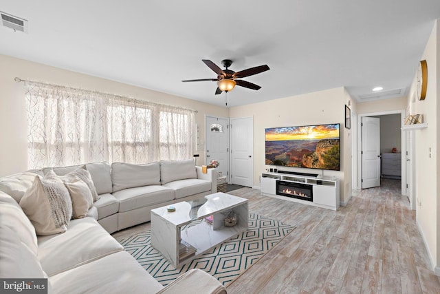 living room featuring ceiling fan and light wood-type flooring