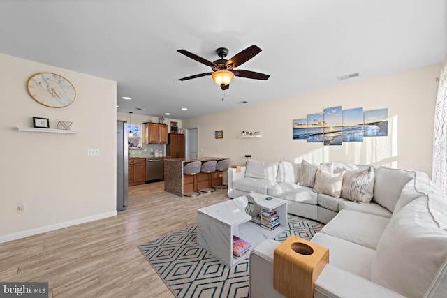 living room with ceiling fan and light wood-type flooring