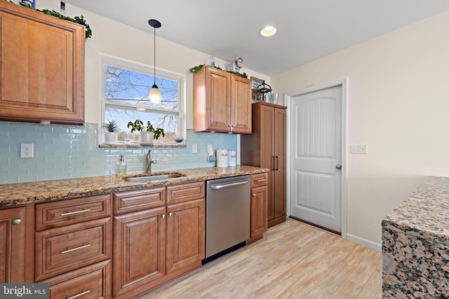 kitchen featuring sink, tasteful backsplash, dishwasher, light stone countertops, and light hardwood / wood-style floors