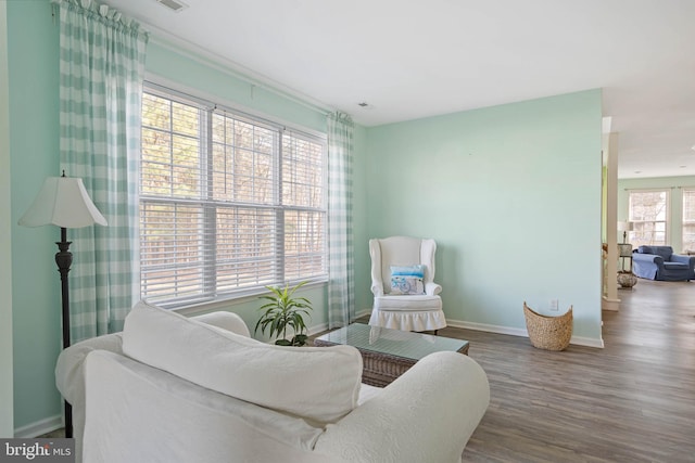 living area with baseboards and wood finished floors