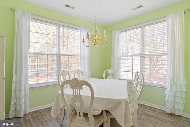 dining area featuring baseboards, visible vents, and wood finished floors