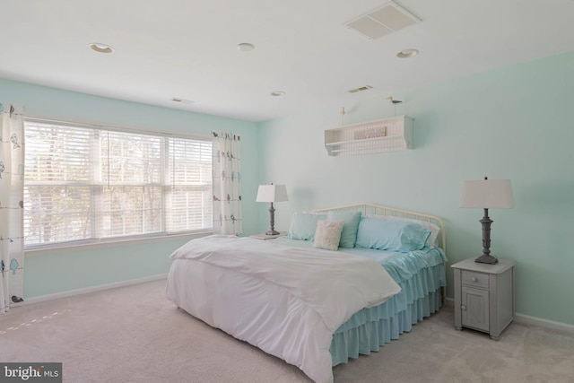 bedroom with light carpet, visible vents, and baseboards