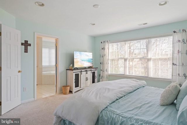 carpeted bedroom with recessed lighting, visible vents, and ensuite bath