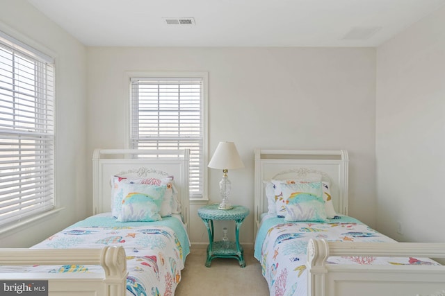 bedroom featuring carpet, visible vents, and multiple windows