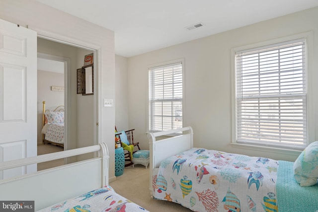 carpeted bedroom featuring visible vents