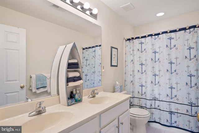 full bath featuring visible vents, double vanity, a sink, and toilet