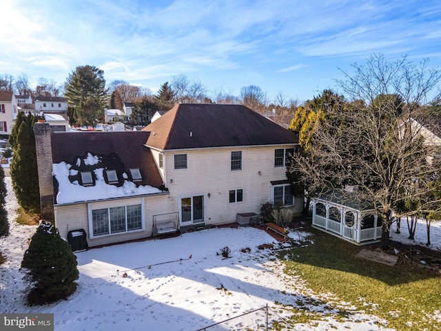 view of snow covered rear of property