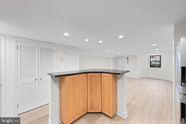 kitchen with fridge with ice dispenser and light wood-type flooring