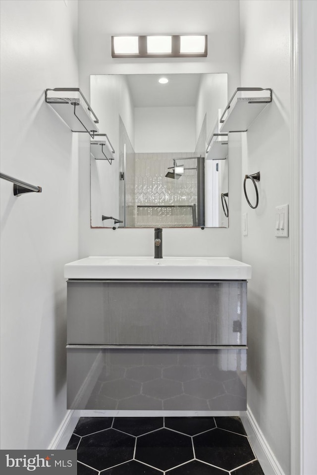 bathroom featuring vanity, a tile shower, and tile patterned floors