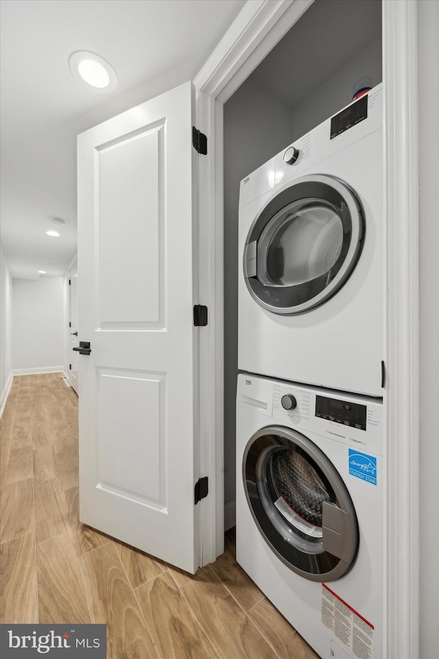 clothes washing area featuring stacked washing maching and dryer