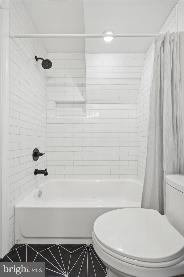 bathroom featuring shower / tub combo with curtain, toilet, and tile patterned floors