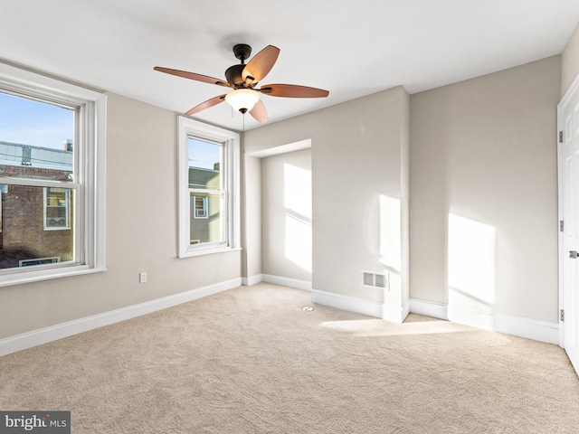 unfurnished room with light colored carpet and ceiling fan