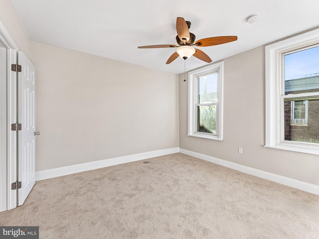 empty room with ceiling fan and light colored carpet