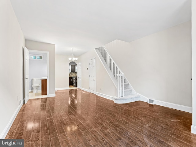 unfurnished living room with hardwood / wood-style flooring and a chandelier