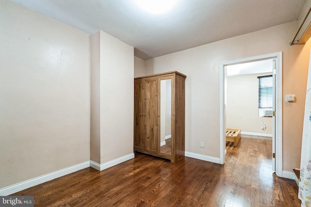 unfurnished bedroom with dark wood-type flooring