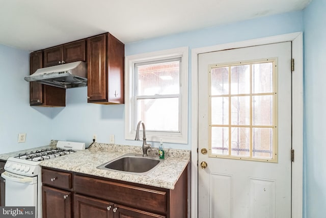 kitchen featuring dark brown cabinetry, sink, light stone countertops, and white range with gas stovetop