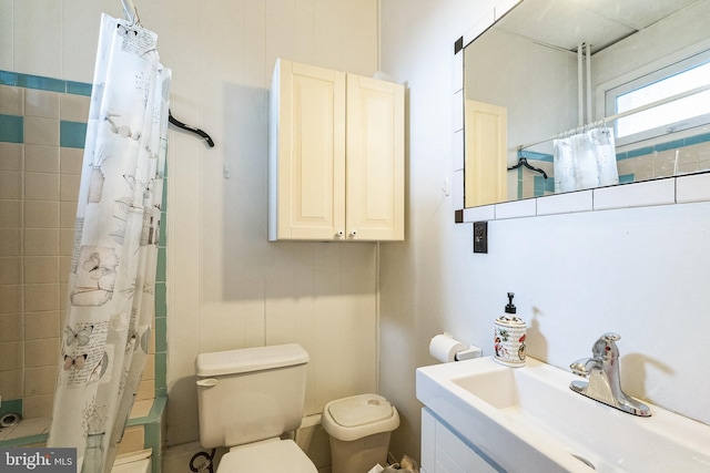 bathroom featuring a shower with curtain, toilet, and sink