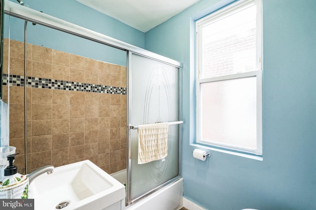 bathroom featuring sink and shower / bath combination with glass door