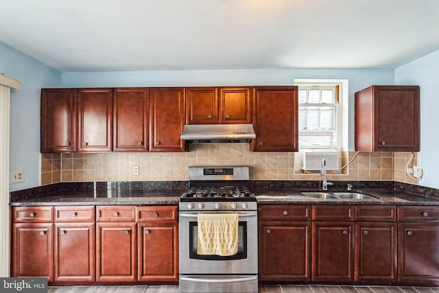 kitchen featuring dark stone countertops, sink, gas range, and decorative backsplash