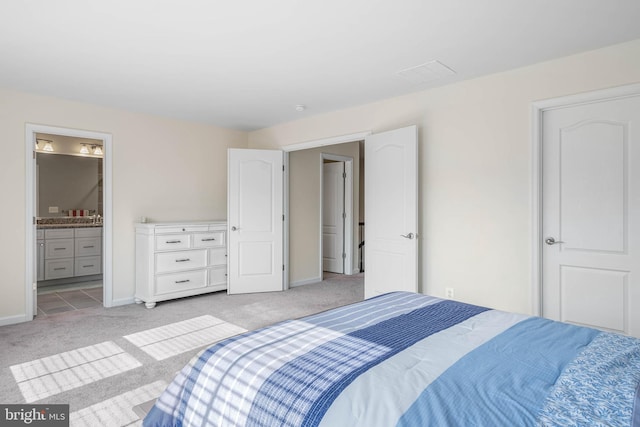 bedroom with light colored carpet and ensuite bathroom