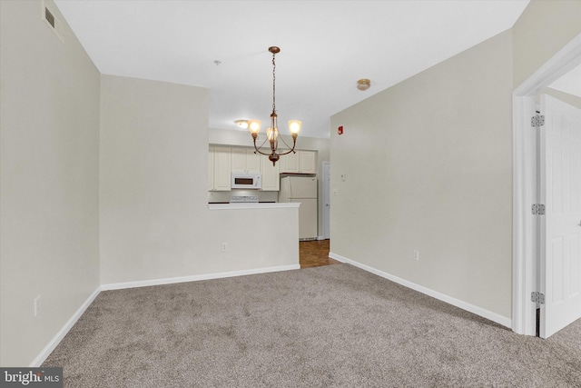 unfurnished living room with carpet and an inviting chandelier