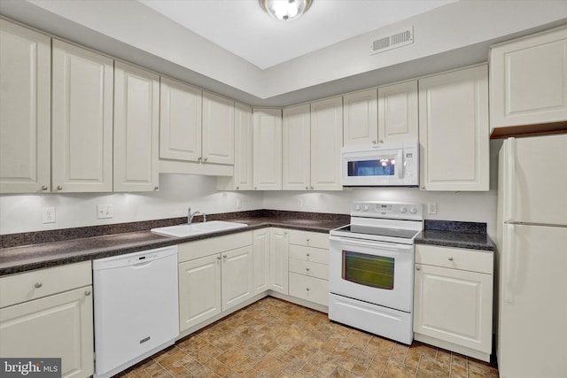 kitchen featuring white cabinetry, sink, and white appliances