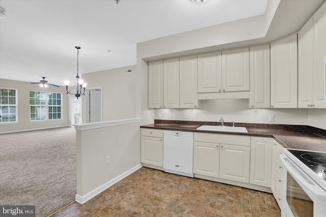 kitchen featuring pendant lighting, sink, white appliances, white cabinetry, and light carpet