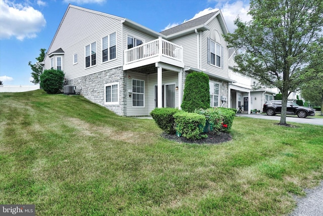 view of property exterior with central AC and a lawn