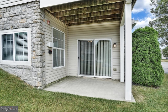 view of exterior entry with a patio area