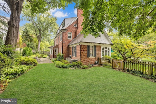 view of property exterior featuring central AC unit, a patio area, and a lawn