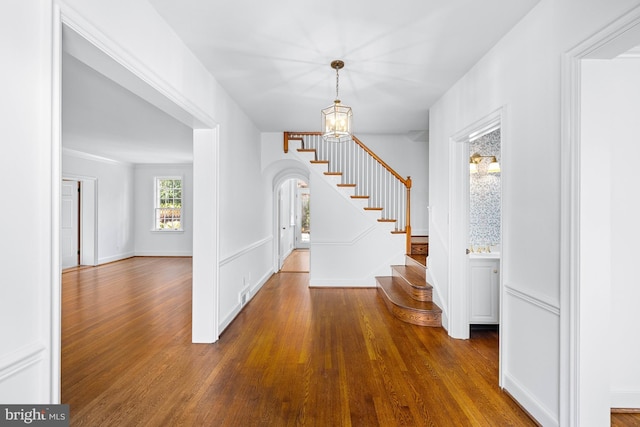 foyer entrance with dark wood-type flooring and a chandelier