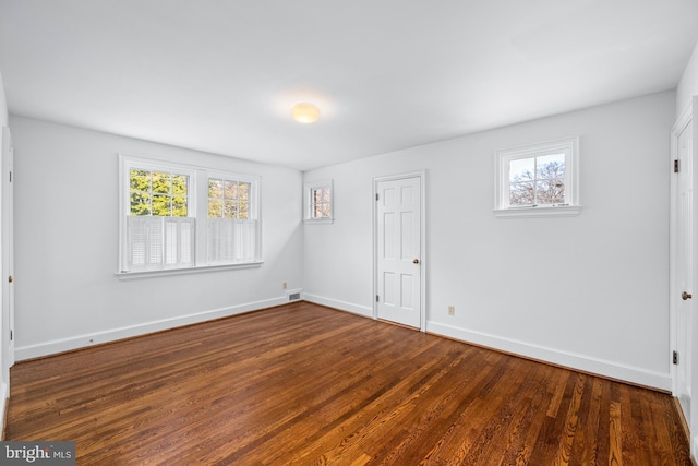 empty room featuring dark hardwood / wood-style floors and a wealth of natural light