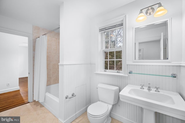 full bathroom with shower / bathtub combination with curtain, tile patterned floors, toilet, and sink