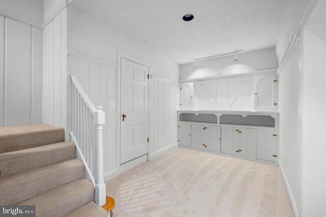 interior space with track lighting and a textured ceiling