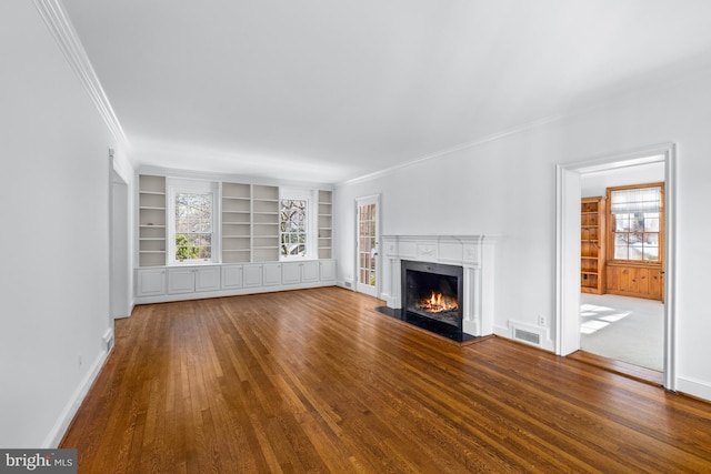 unfurnished living room featuring a premium fireplace, wood-type flooring, built in features, and ornamental molding