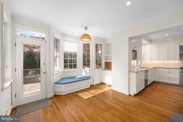 kitchen featuring sink, light hardwood / wood-style flooring, dishwasher, pendant lighting, and white cabinets