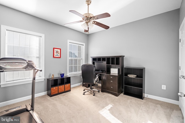 office space featuring light carpet and ceiling fan