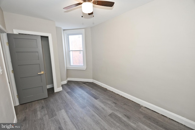 unfurnished bedroom with a ceiling fan, baseboards, and wood finished floors