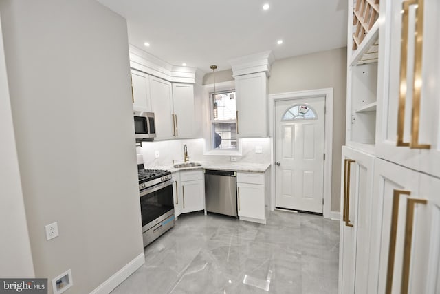 kitchen with decorative light fixtures, stainless steel appliances, decorative backsplash, white cabinets, and a sink