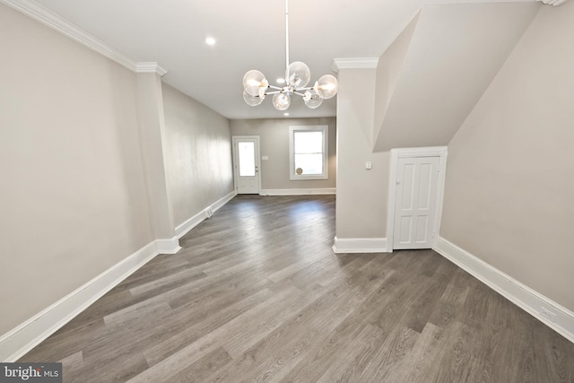 unfurnished dining area with ornamental molding, an inviting chandelier, dark wood finished floors, and baseboards