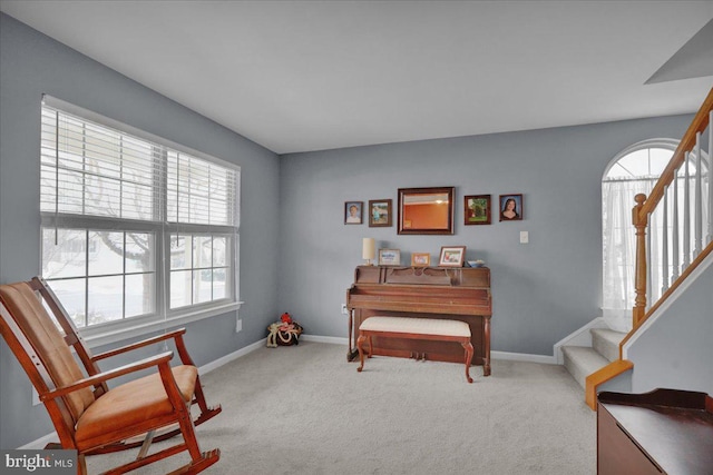 living area featuring a wealth of natural light and light colored carpet