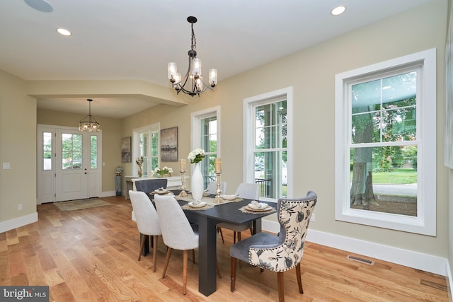 dining space with an inviting chandelier and light hardwood / wood-style flooring