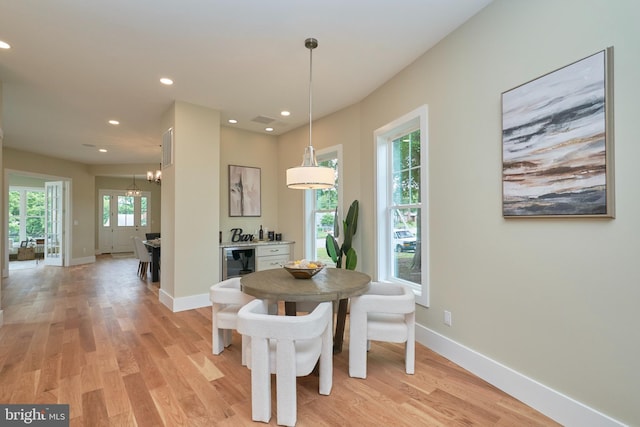 dining space with wine cooler and light wood-type flooring