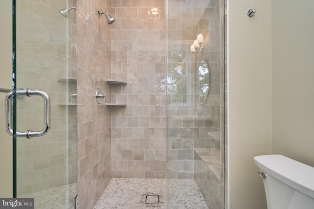 bathroom with a shower with door and toilet