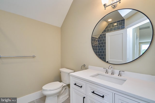 bathroom with vanity, lofted ceiling, and toilet