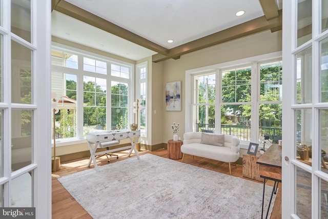 sunroom / solarium featuring plenty of natural light and beam ceiling