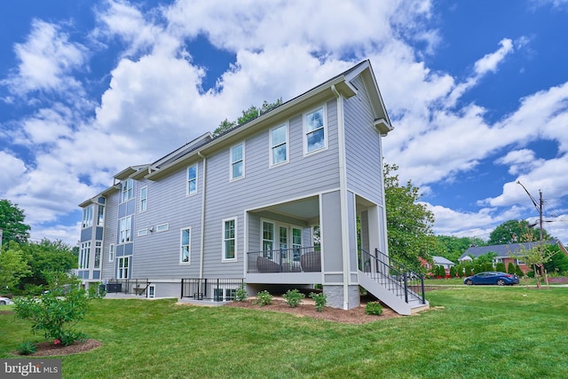 rear view of property featuring a lawn