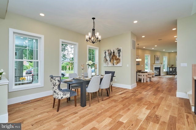 dining space featuring an inviting chandelier and light hardwood / wood-style flooring