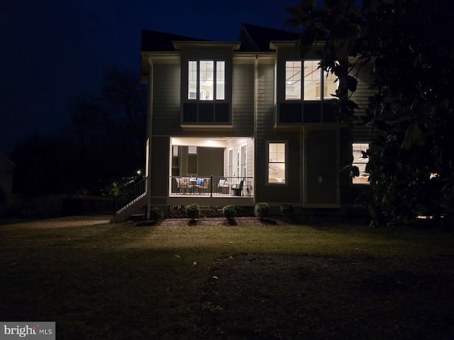 back house at night featuring covered porch